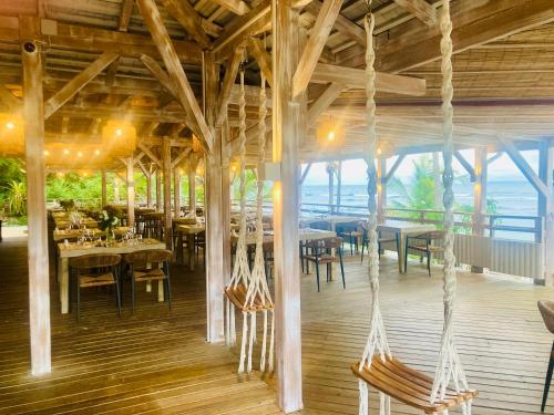 a restaurant with wooden ceilings and tables and chairs at TIKAZADAPH, pour un séjour de charme, romantique & exotique, 97180 Sainte-Anne in Sainte-Anne