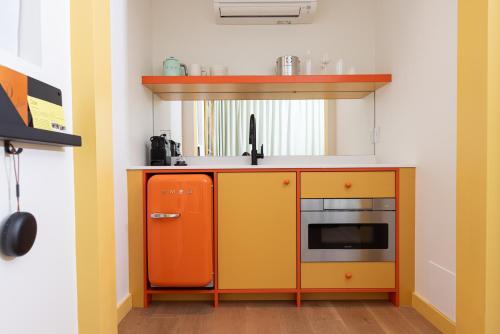 a kitchen with an orange cabinet and a microwave at Ode in Toronto