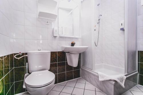 a white toilet sitting next to a sink in a bathroom at Hotel Twins in Warsaw