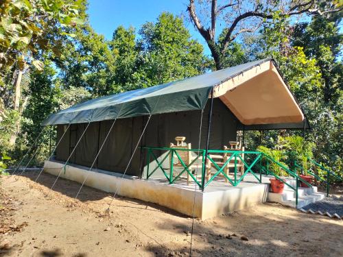 a tent with a table and chairs in it at Athulyam Kanha, kanha national park, mukki gate in Khāpa
