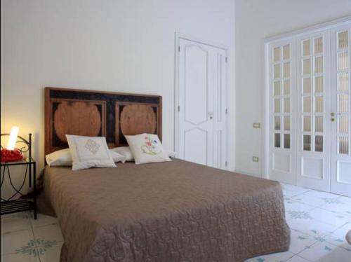 um quarto com uma cama grande e 2 almofadas em Palazzo Morese Apartments em Salerno