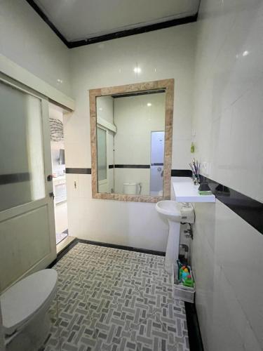 a bathroom with a toilet and a sink and a mirror at Gladstudio in Kerobokan