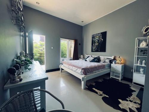 a bedroom with a large bed and a window at Gladstudio in Kerobokan
