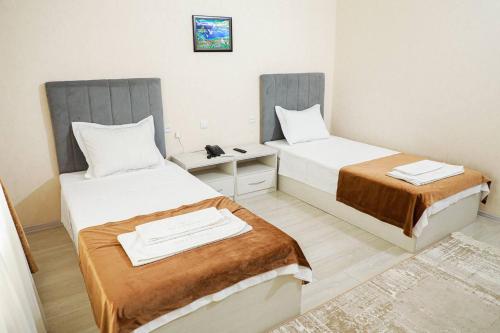 a room with two beds in a room at Gold Palace in Termiz