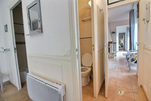 a bathroom with a toilet and a hallway at Huna lulu in Pleslin-Trigavou