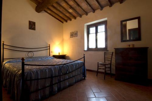 a bedroom with a bed and a window and a chair at Casa il Ponte in Chianni