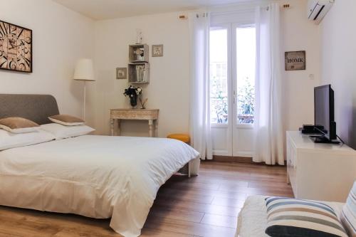 une chambre avec un lit, une télévision et une fenêtre dans l'établissement Studio Chateau - Vieux Nice, à Nice