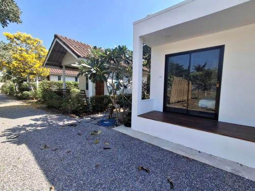 a house with a window on the side of it at Homlomchomsuan หอมลมชมสวน in Ban Mai
