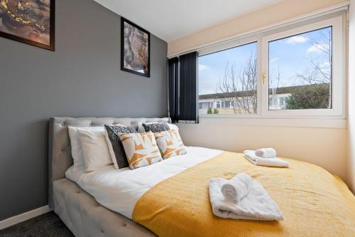 a bedroom with a large bed with towels on it at Large spacious and spotless house with hot tub and snooker and table tennis NEC,JLR,Airport Sleeps 8 in Water Orton