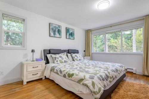 ein Schlafzimmer mit einem Bett und zwei Fenstern in der Unterkunft Rina's yellow house in Sammamish