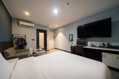 a hotel room with a large bed and a television at Sopoong Hotel Incheon in Incheon