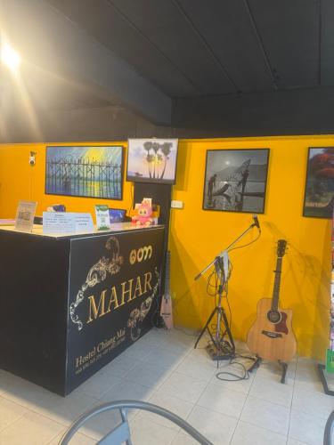 a room with a stage with a guitar and a microphone at MaHar Hostel ChiangMai in Chiang Mai