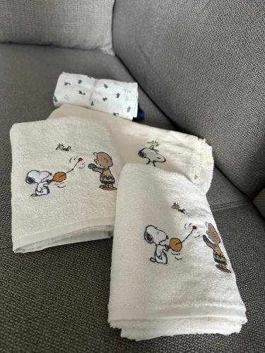 two white pillows with cartoon animals on them on a couch at Modern Elegance in historical City Center in Trier