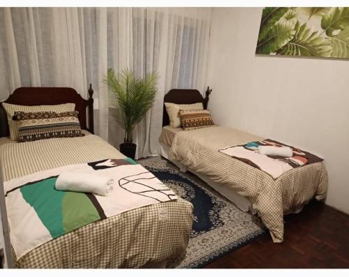 two beds sitting next to each other in a room at Sohostay in Kuala Terengganu