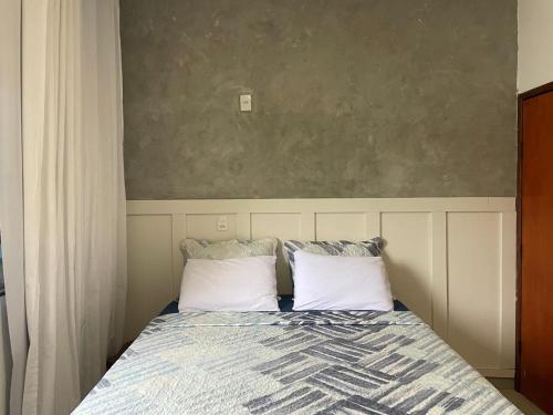 a bedroom with a bed with two pillows at Apartamento no Centro in Palmas