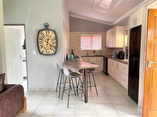 a kitchen with a table and a clock on the wall at TeenyTawny at the Vaal River in Parys