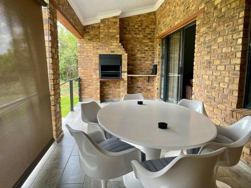 a room with a white table and white chairs at TeenyTawny at the Vaal River in Parys