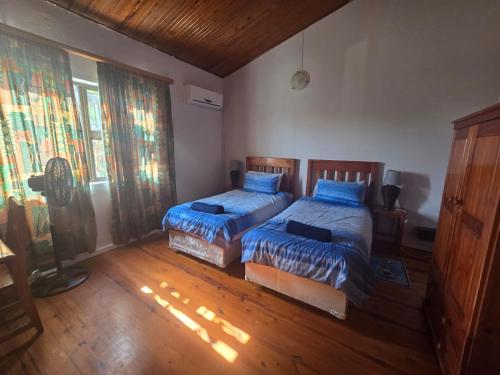 a bedroom with two beds and a fan at Reefteach Lodge in Sodwana Bay