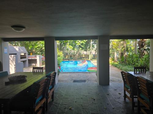 a dining room with a table and chairs and a pool at Reefteach Lodge in Sodwana Bay