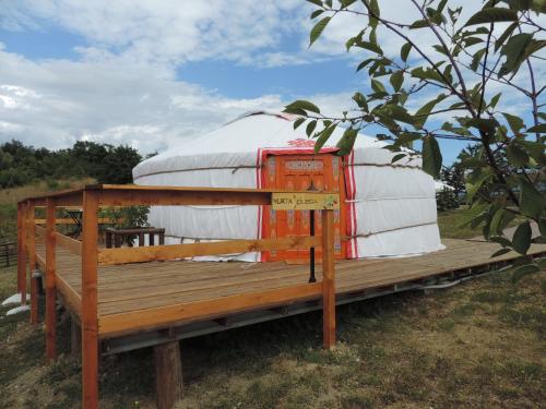 a yurt sitting on a bench in a field at Società Agricola Cacigolara in Borgo Val di Taro