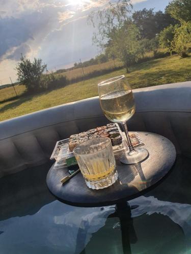 - un verre de vin sur une table au bord de la piscine dans l'établissement Grande maison au calme, à Véretz