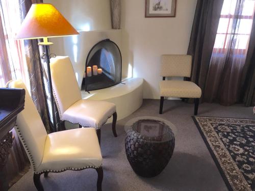 a living room with a chair and a fireplace at Casa de Tres Lunas/House of Three Moons in Santa Fe
