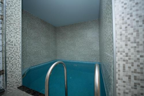 a bathroom with a blue tub in a room at Gоderdzi Twins Hotel in Goderdzi