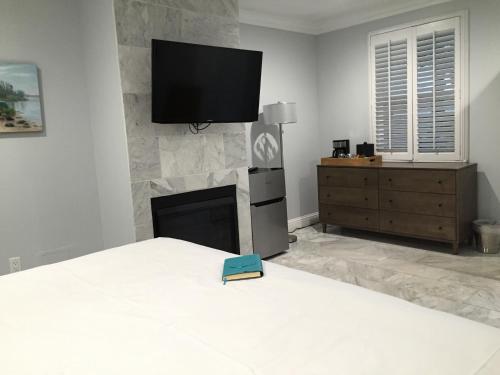 a bedroom with a bed with a tv above a fireplace at Beach Bungalow Inn and Suites in Morro Bay
