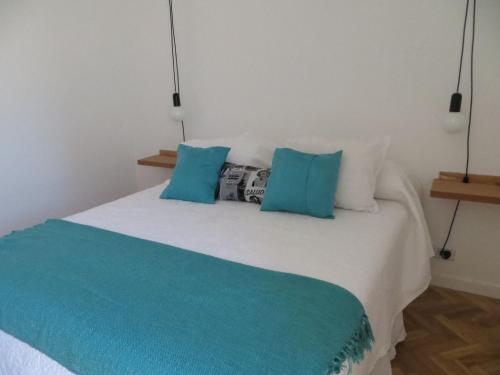a bedroom with a bed with blue and white pillows at Sunny Recoleta Apartment in Buenos Aires
