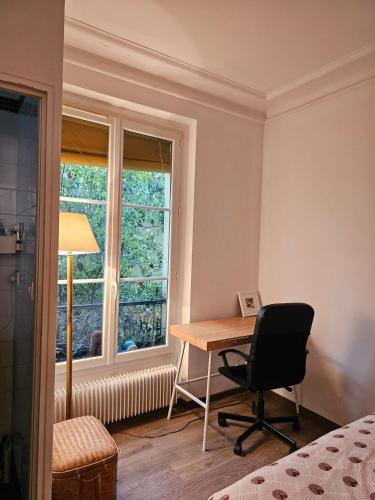 Cette chambre dispose d'un bureau, d'une chaise et d'une fenêtre. dans l'établissement Buttes Chaumont apartement, à Paris