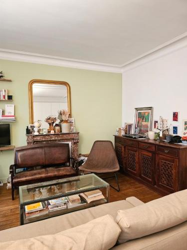 un salon avec un canapé et un miroir dans l'établissement Buttes Chaumont apartement, à Paris