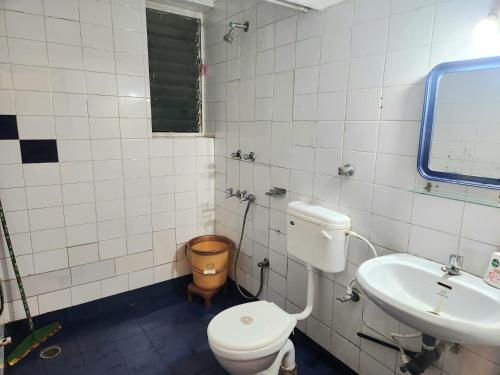 a bathroom with a toilet and a sink at Calangute Beachside Apartment by Welkin stays in Calangute