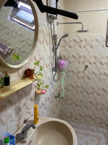 une salle de bain avec un lavabo et une douche avec un miroir dans l'établissement Madiha home staying, à Matara
