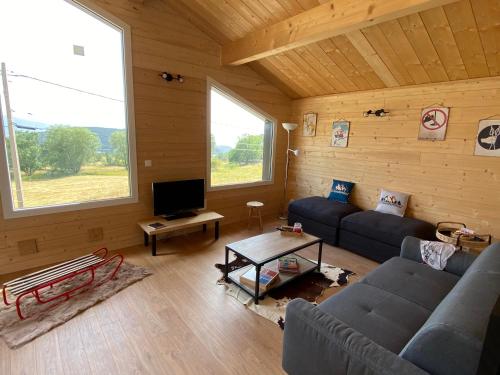 a living room with a couch and a tv at Chalet des loulous , 3 chambres, 8 couchages in Font Romeu Odeillo Via