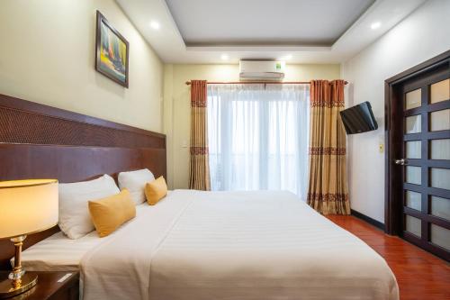 a bedroom with a large white bed and a window at Shine Hue Hotel 2 in Hue