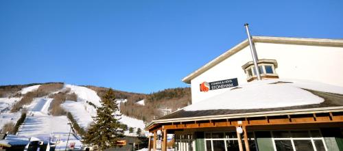 un edificio con una montaña cubierta de nieve en el fondo en Hotel Stoneham, en Stoneham