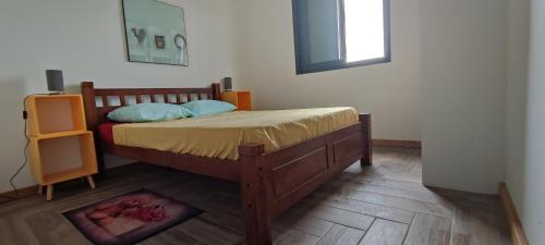 a bedroom with a wooden bed and a window at Villa la fournaise in Le Tampon