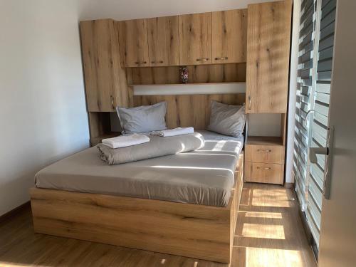 a bedroom with a bed with a wooden wall at Cãbãnuţe - Lac Maleia in Dobreşti