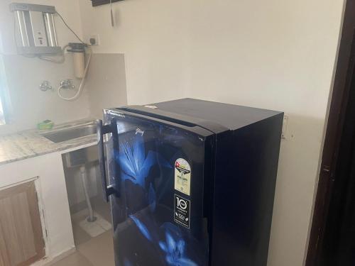 un réfrigérateur noir dans le coin d'une cuisine dans l'établissement White House shikargarah Jodhpur, à Jodhpur