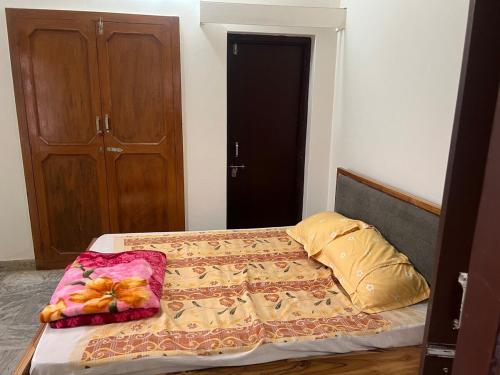 - une petite chambre avec un lit doté d'un couvre-lit et d'oreillers dans l'établissement White House shikargarah Jodhpur, à Jodhpur