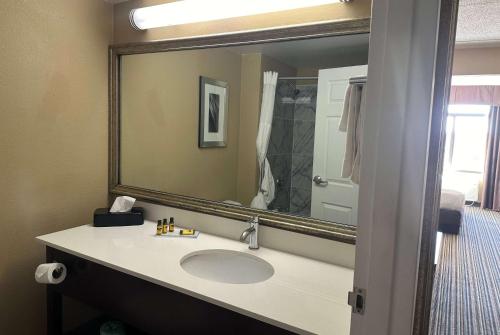 a bathroom with a sink and a large mirror at Wingate by Wyndham Harrisburg Near Hershey in Harrisburg