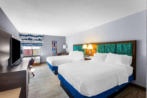 a hotel room with two beds and a flat screen tv at Hampton Inn Marion in Marion