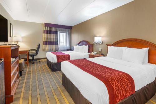 a hotel room with two beds and a television at Comfort Inn University Center in Fairfax