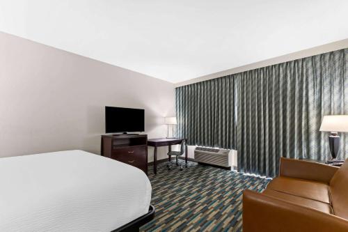 a hotel room with a bed and a desk at Days Inn & Suites by Wyndham Mesa Near Phoenix in Mesa