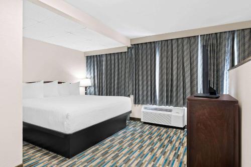 a hotel room with a bed and a large window at Days Inn & Suites by Wyndham Mesa Near Phoenix in Mesa