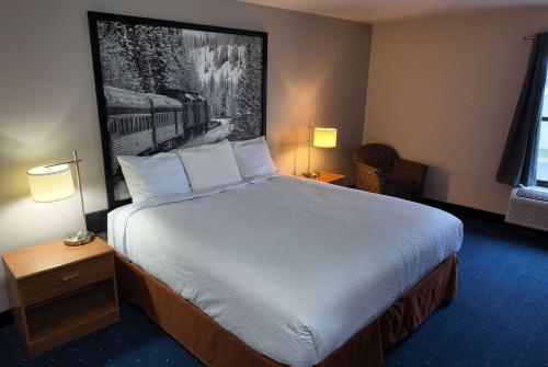 a hotel room with a large bed with two lamps at Super 8 by Wyndham Hampshire IL in Hampshire