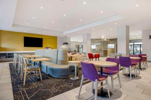 a restaurant with tables and chairs and a tv at Home2 Suites By Hilton Colorado Springs Airport in Colorado Springs