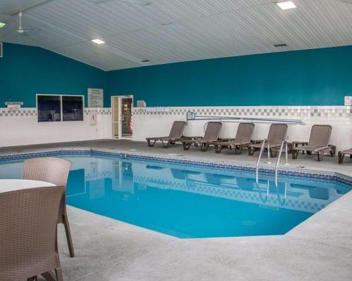 a swimming pool with chairs and a blue wall at Sleep Inn Sandusky in Sandusky