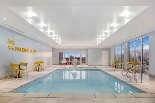 a pool in a hotel room with yellow chairs and tables at Home2 Suites By Hilton Colorado Springs Airport in Colorado Springs