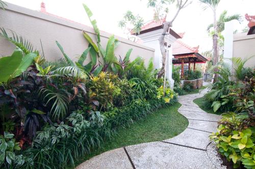 a garden path in front of a house with plants at Villa Puspa in Tanah Lot